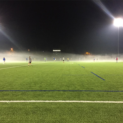 students playing soccer on hazy pitch on Harrison Field